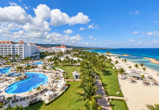 Luxury adults-only oceanfront resort complex surrounded by palm trees and turquoise Caribbean waters in Runaway Bay Jamaica.