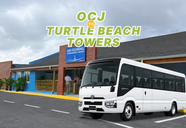 White Toyota Coaster passenger bus parked in front of Ian Fleming International Airport terminal for group transfer to Turtle Beach Towers.